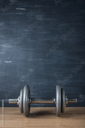 metal barbell on dark gray background