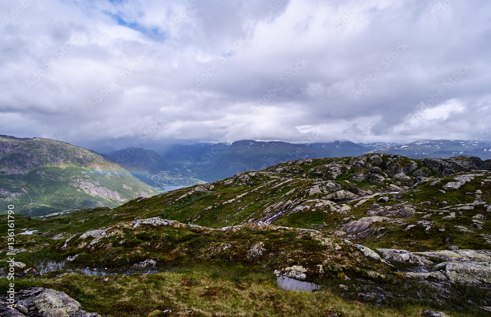 The rough terrain with water from melted snow, a small rainbow and low hanging clouds, on the way to Stordalsnibba The rough terrain with water from melted snow, a small rainbow and low hanging clouds, on the way to Stordalsnibba