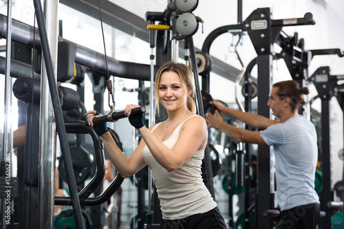 Young adults working out in fitness club.