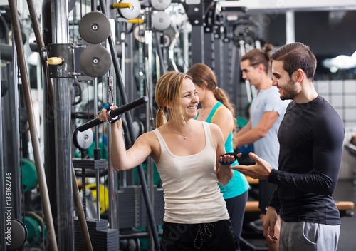 Adults doing powerlifting on machines