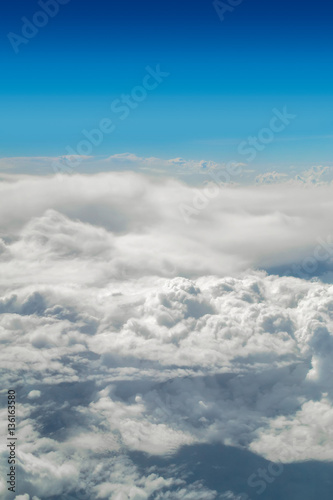 Cloudscape with blue sky above vertical image.