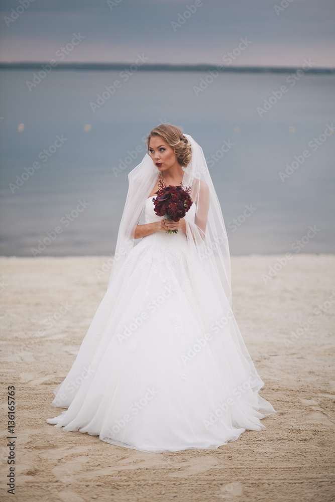 Portrait of beautiful bride in wedding day on the shore of the sea. Portrait of beautiful bride in wedding day on the shore of the sea.
