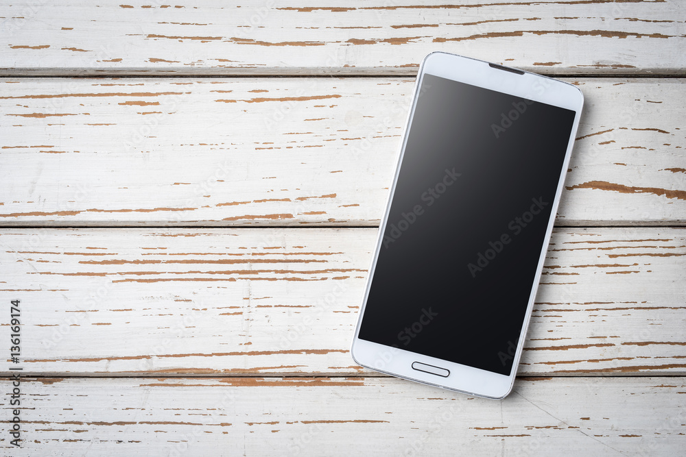 White smart phone on an old wooden table White smart phone on an old wooden table