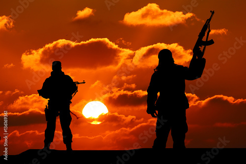 Two silhouette of a soldier on a beautiful background © YURII Seleznov