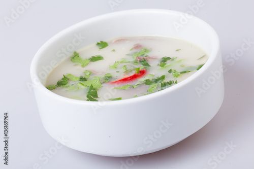 A plate with cream soup on gray background.