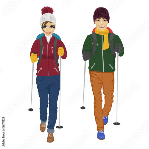 young couple with backpack and hiking walking sticks