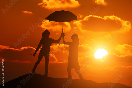 silhouette two girls on the background of a beautiful sunset holding umbrella © YURII Seleznov