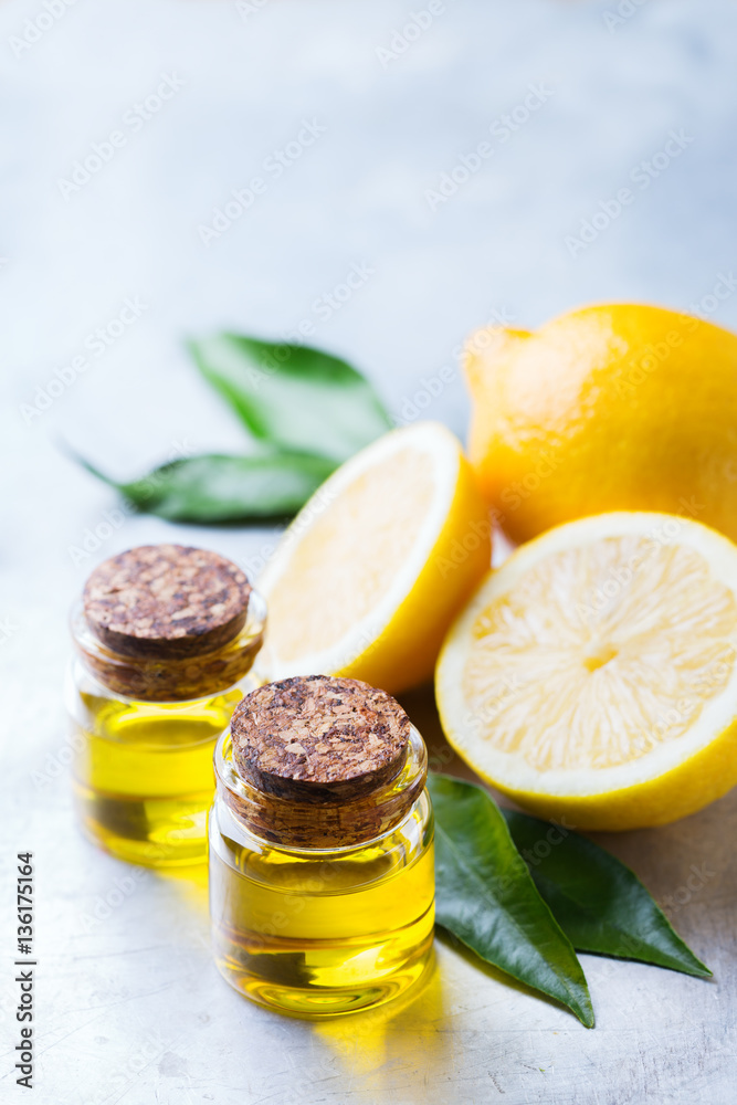 Organic essential lemon oil with green leaves and fruit Organic essential lemon oil with green leaves and fruit