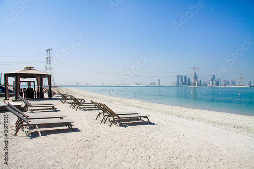 Luxury beach lounge club with stylish sunbeds and canopy in Abu Dhabi  Saadiyat  Paradise  island  United Arabian Emirates  UAE  in front of skyscrapers