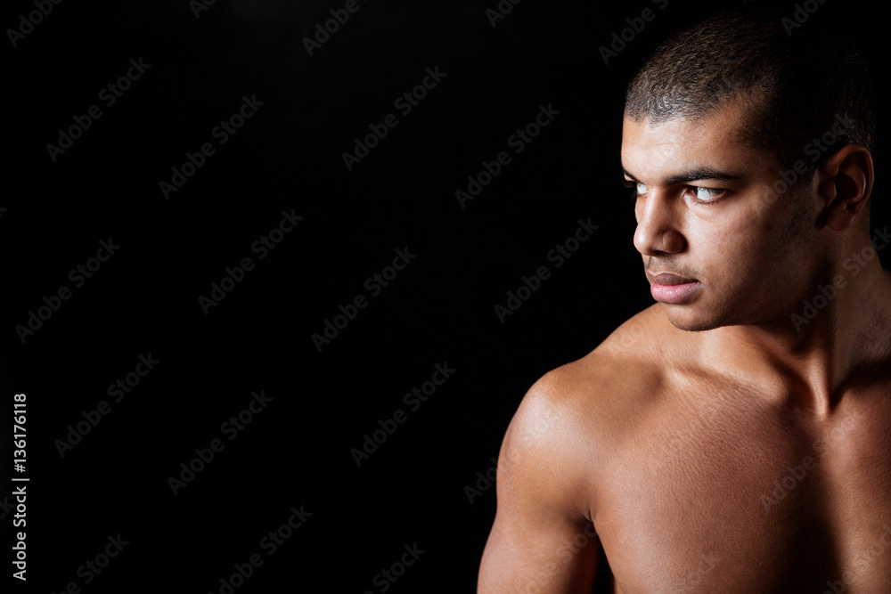 Serious naked african american young man standing and looking away Serious naked african american young man standing and looking away