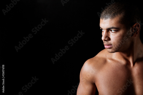 Serious naked african american young man standing and looking away