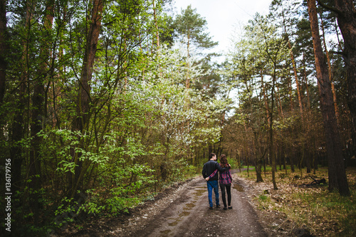Happy young couple walking through the forest