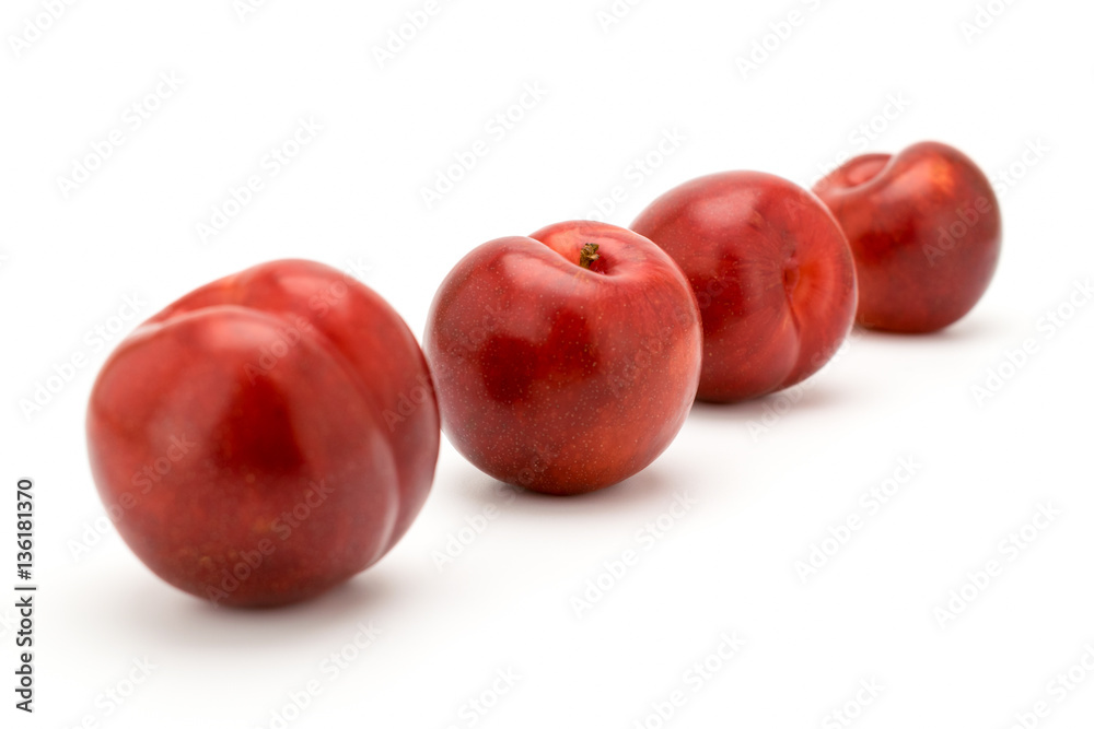 Four ripe cherries on a white
