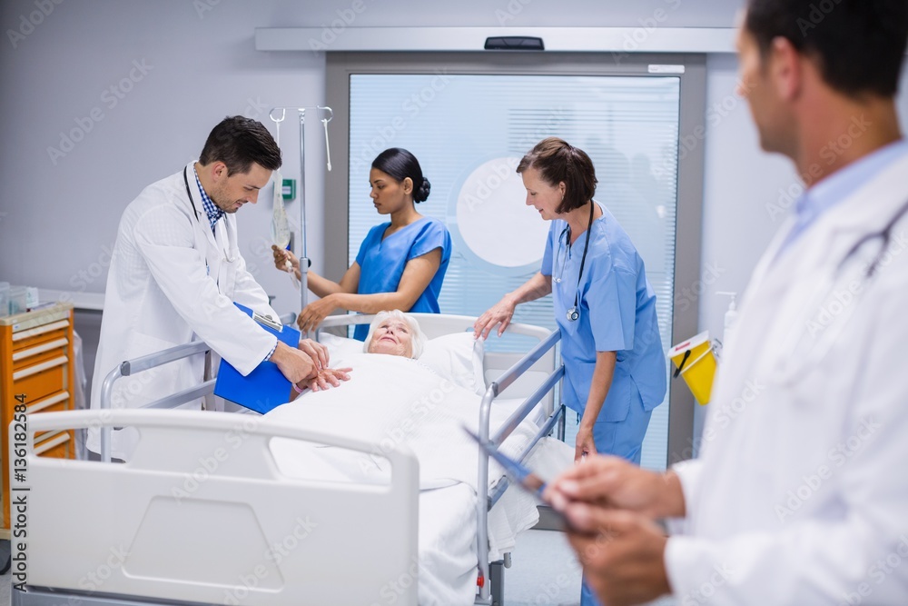 Doctors examining patient in ward Doctors examining patient in ward