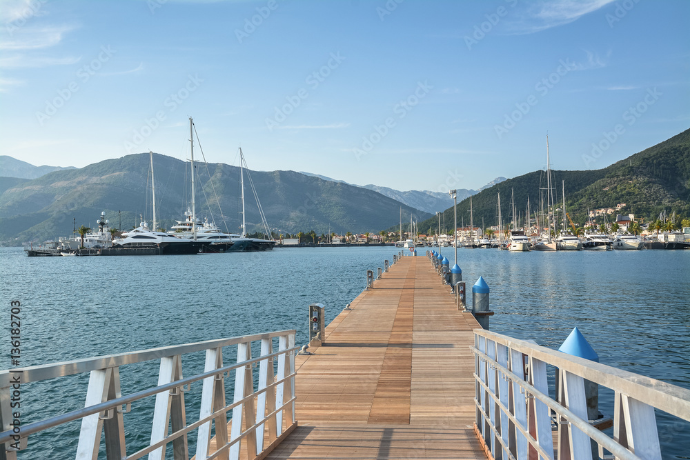 Empty pier for yachts and city on the shore in the background