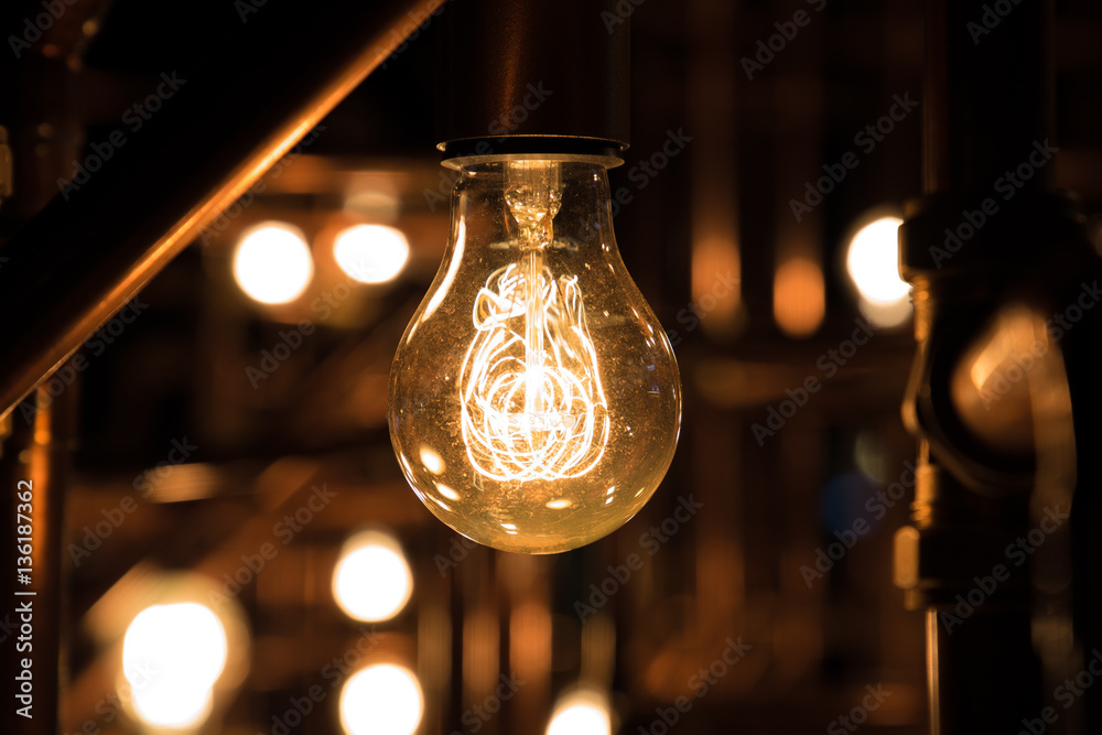Incandescent light bulb between rusty pipes Incandescent light bulb between rusty pipes