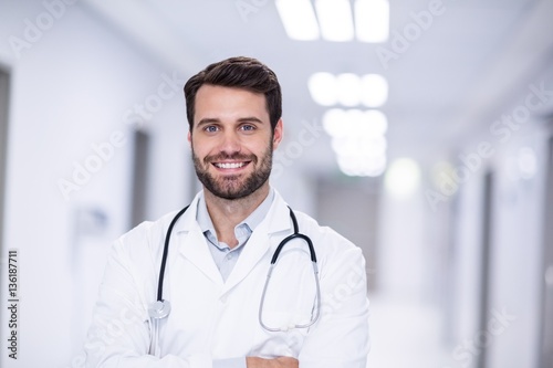 Portrait of male doctor standing with arms crossed photo
