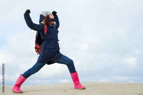 energetic funny young woman enjoying life and posing on on winter beach. energy, strength, power, success concept