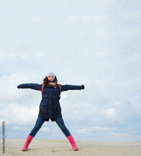 energetic funny young woman enjoying life and posing on on winter beach. energy, freedom, success concept