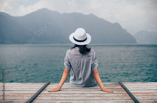 Beautiful woman relaxing on pier in Garda Lake