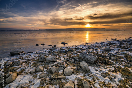 Traumhafter Sonnenuntergang am Bodensee mit Steinen am Seeufer