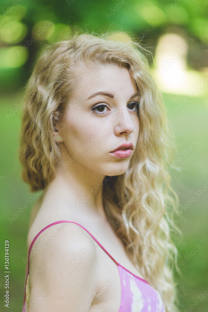 Portrait of young beautiful caucasian blonde hair woman outdoor in a city park, overlooking, serene - beauty, hair care, skin care concept Portrait of young beautiful caucasian blonde hair woman outdoor in a city park, overlooking, serene - beauty, hair care, skin care concept