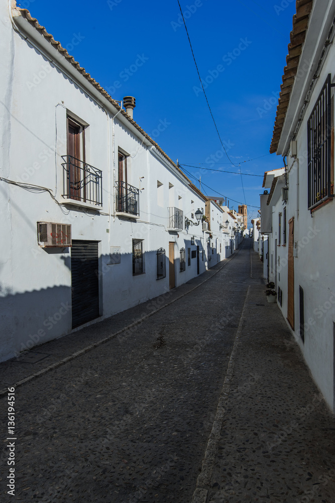 narrow street with white houses in Spain