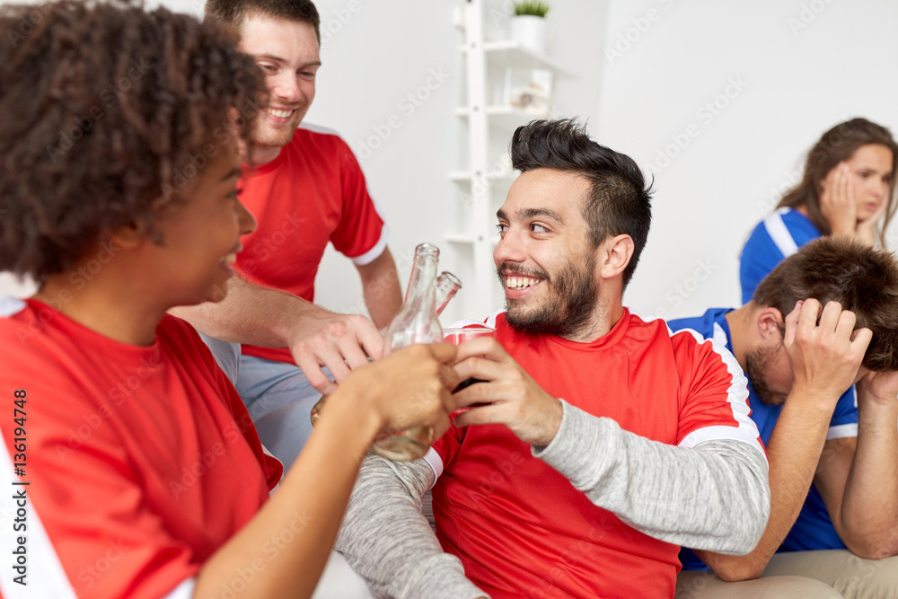 Obraz premium happy football fans or friends with beer at home