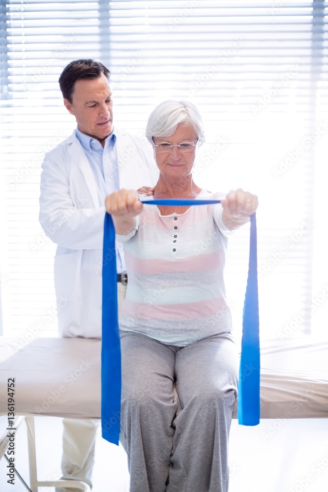 Obraz premium Male physiotherapist giving shoulder massage to senior woman
