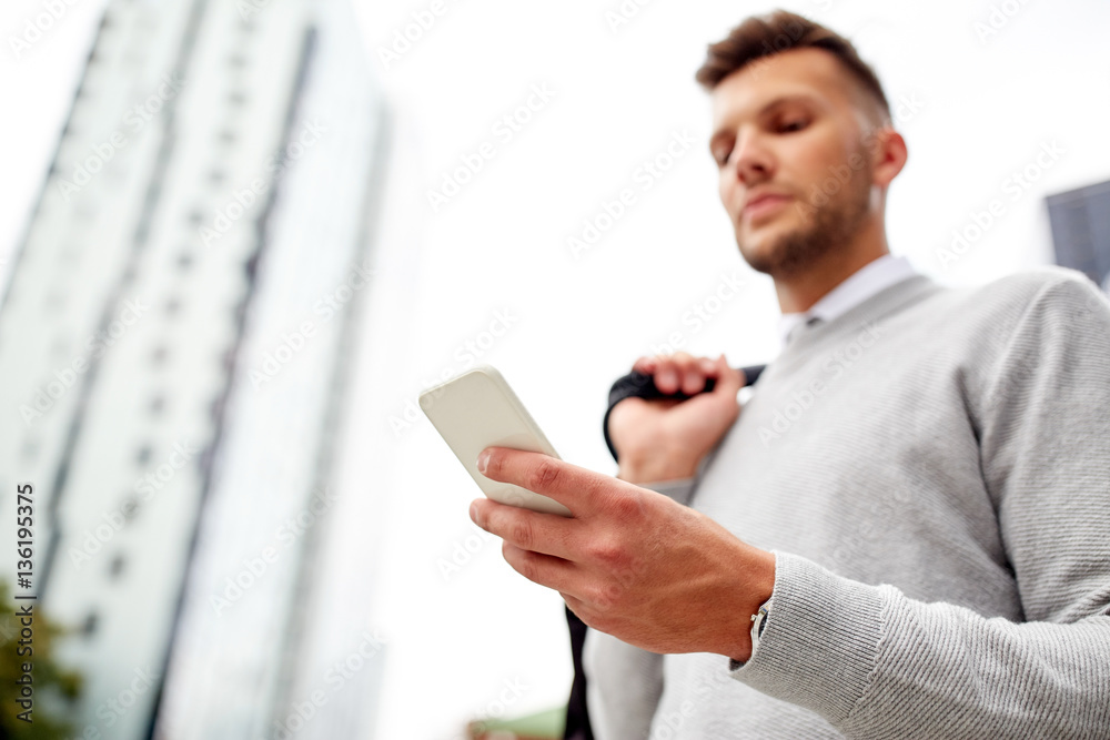close up of man texting on smartphone in city