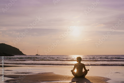 The practice of yoga on the beach at dawn during low tide .Time for peace of mind. Alone with nature. Connection with the universe. © galaganov