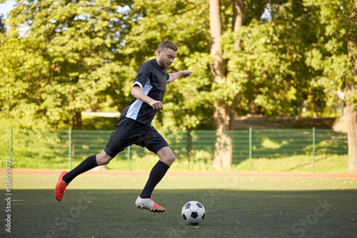 soccer player playing with ball on football field