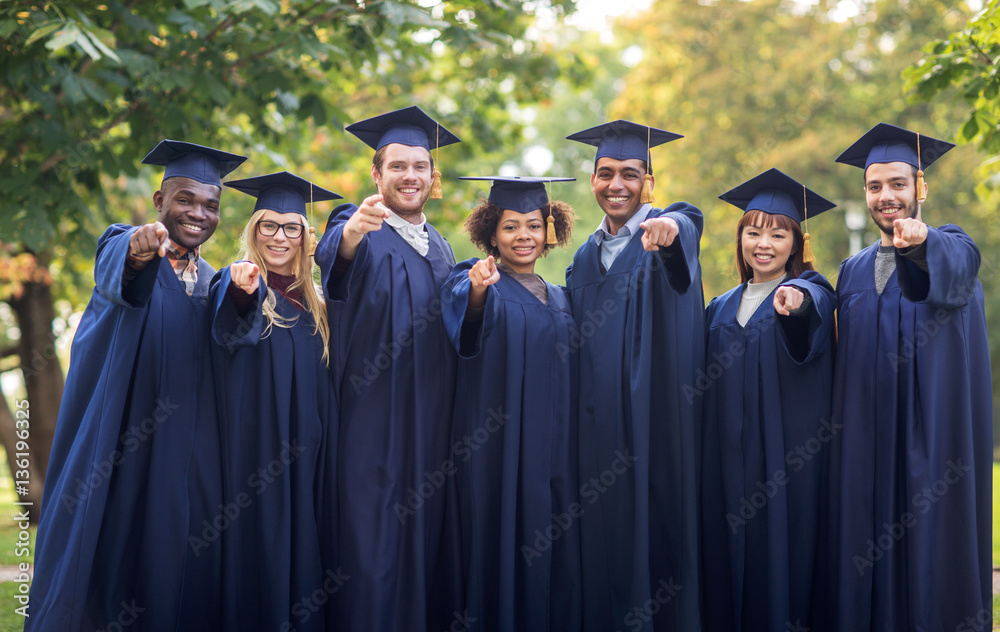 happy students or bachelors pointing finger at you