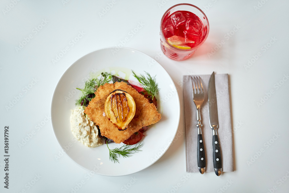 fish salad and glass of drink on restaurant table fish salad and glass of drink on restaurant table