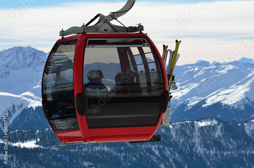 red cable car cabin with skiers in the skiing resort in Alps
