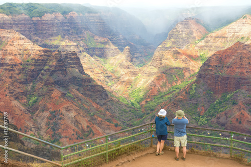 A couple enjoying the beautiful views of the Waimea Canyon lookout, Kauai island, Hawaii photo