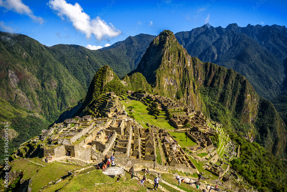 Naklejka premium View of the Lost Incan City of Machu Picchu near Cusco, Peru. Machu Picchu is a Peruvian Historical Sanctuary. People can be seen on foreground.