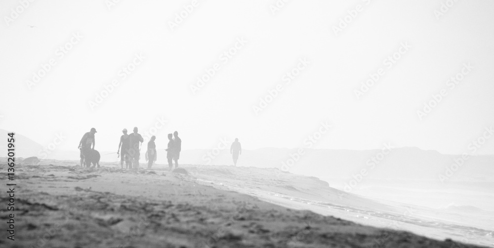 Beach scene in black and white with mist and people, grain is in