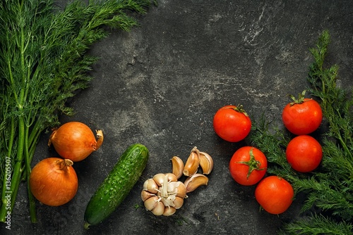 Raw vegetables on a dark black stone background  top view. Copy space above.