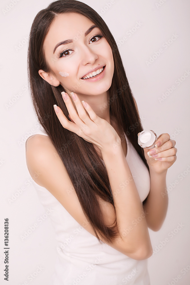 Applying cosmetic cream. A beautiful young woman applying face moisturizer. Scine care of the face and hands Applying cosmetic cream. A beautiful young woman applying face moisturizer. Scine care of the face and hands