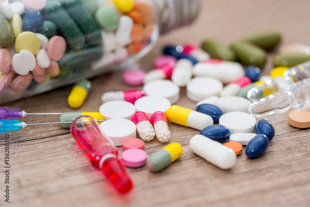 different pills on wooden desk. close up.