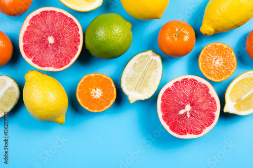 Fototapeta Naklejka Na Ścianę i Meble -  Several kinds of whole and cut citrus on a blue background