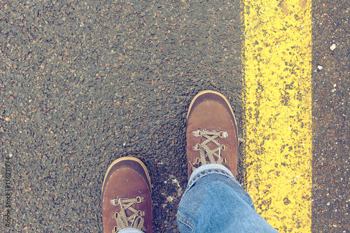 Legs traveler walking on a paved road.