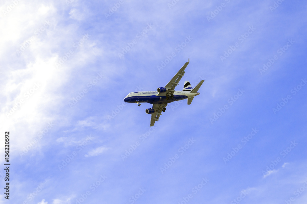Fototapeta premium Landing airplane and beautiful blue sky