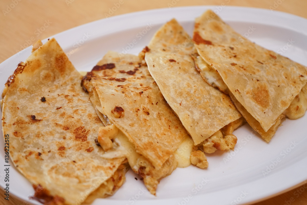 Mexican tortillas with melted cheese and red beans, typical dish of a Mexican restaurant.