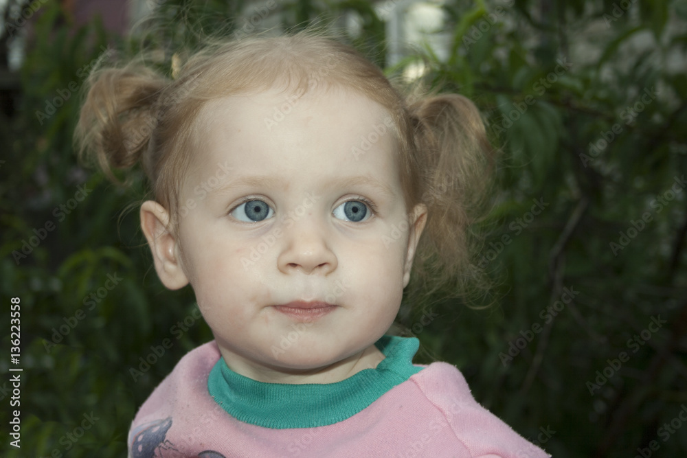 Little blonde girl with a pigtail with emotion stares. Little blonde girl with a pigtail with emotion stares.