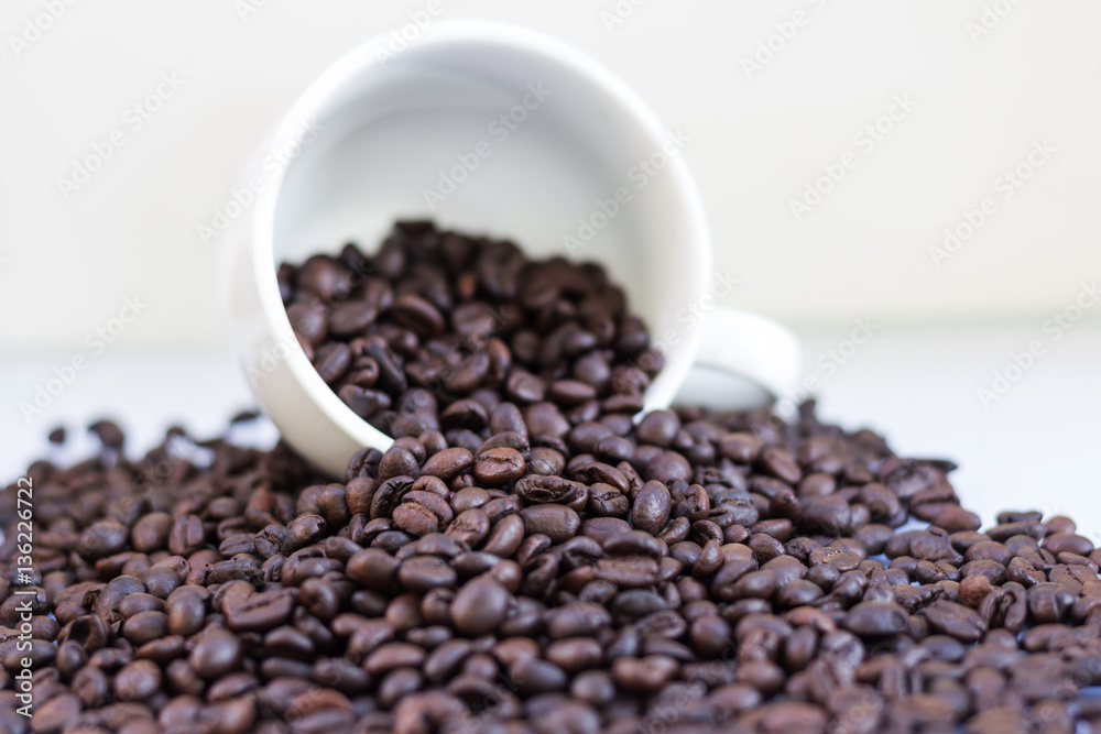 Coffee beans in coffee cup isolated on white Coffee beans in coffee cup isolated on white