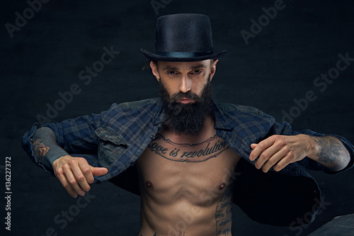 Tattooed bearded male in cylinder hat. © Fxquadro