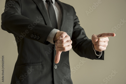 Businessman giving a thumbs down negative vote