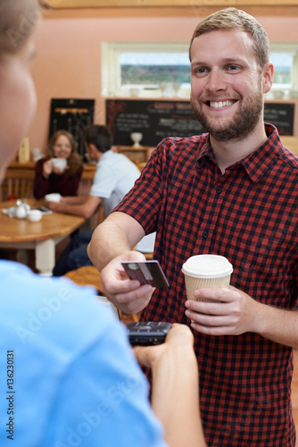 Customer Paying For Takeaway Coffee Using Contactless Terminal